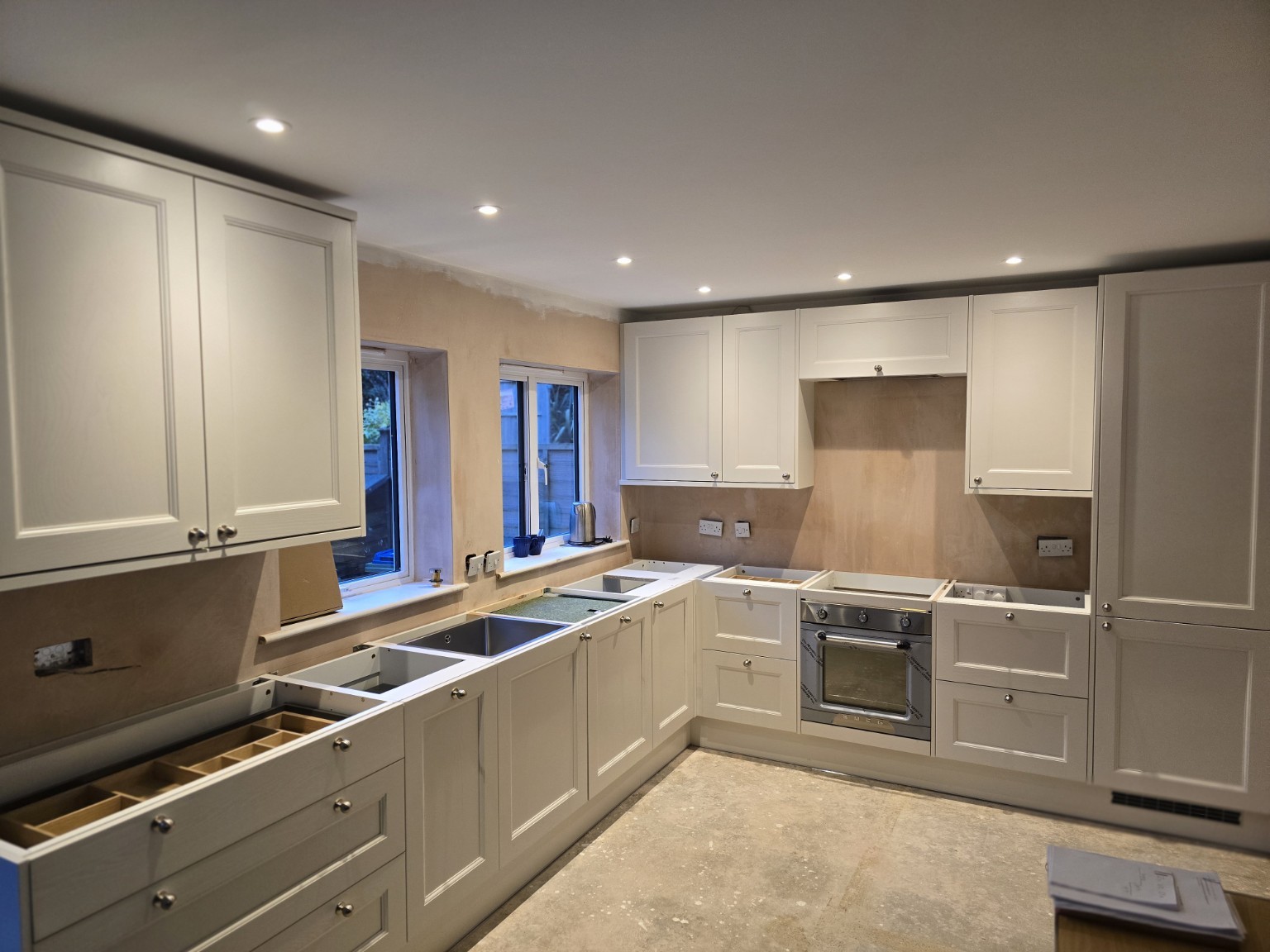 Cream shaker kitchen installation showing fitted cabinetry and oven before worktops are fitted